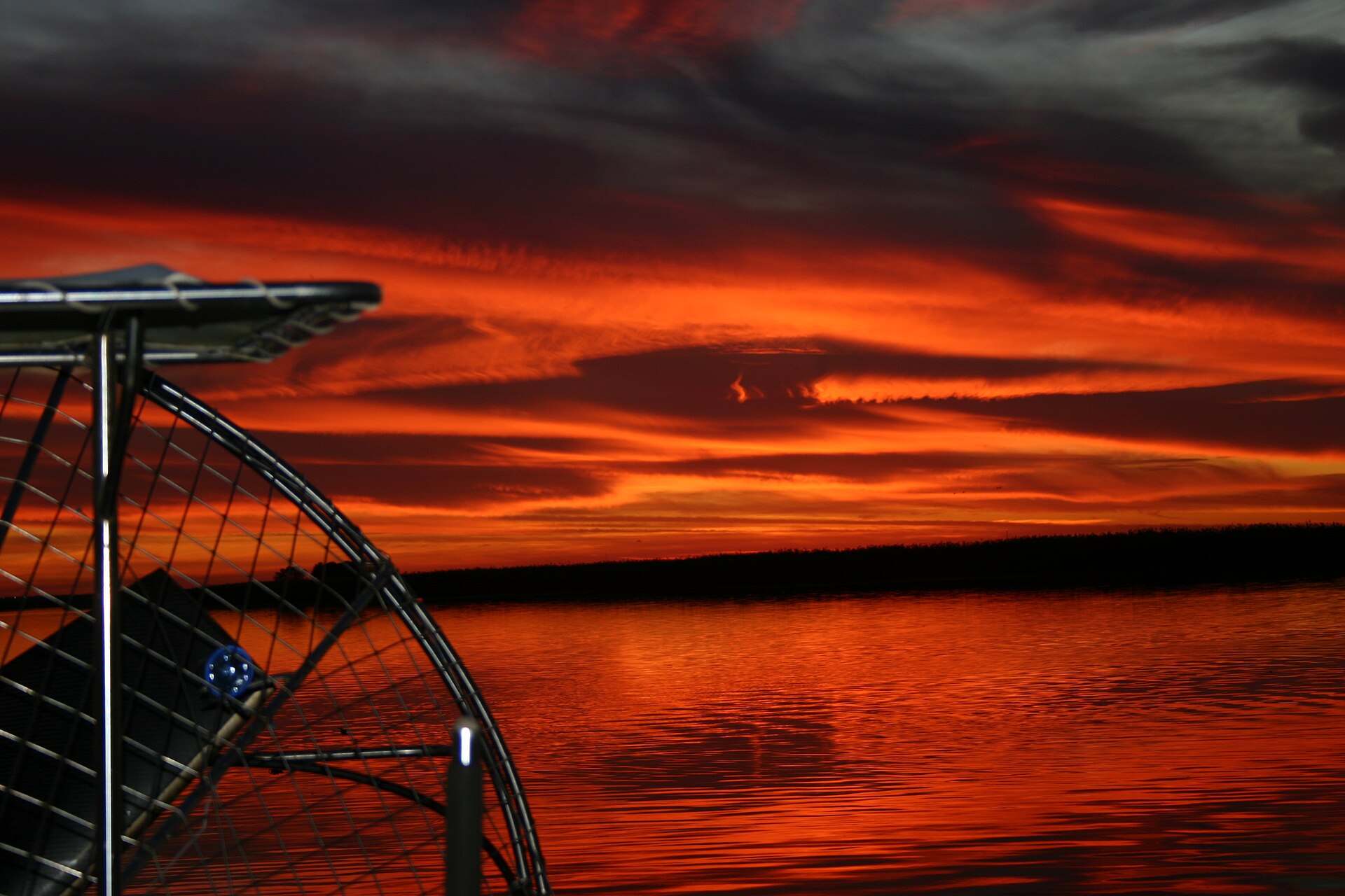 Sunset over Lake Jesup, the sky orange and violet above dark water.