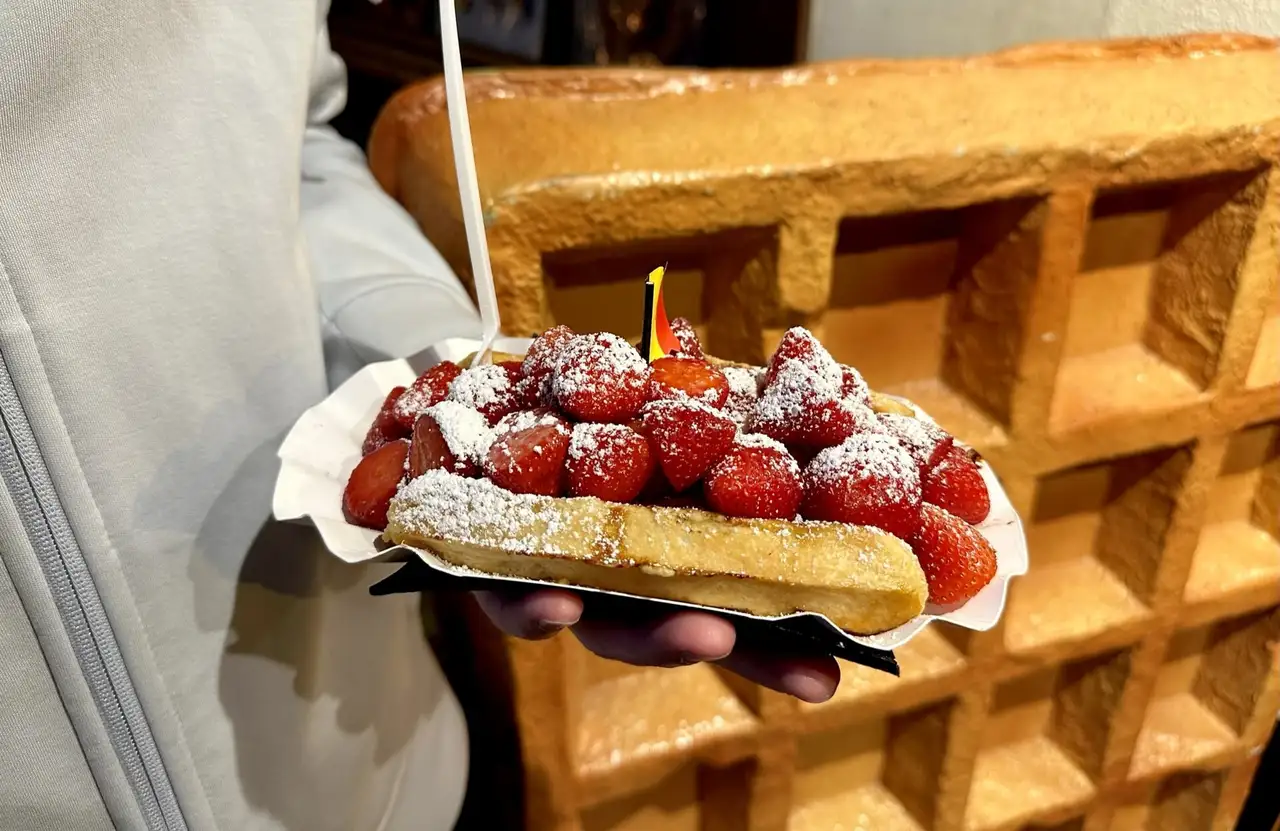 Belgian waffle topped with strawberries and powdered sugar, an illustrative food photograph
